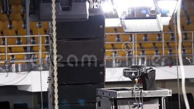 在专业舞台安装期间，现场照明设备正被提升到桁架上。 库存录像。 光线